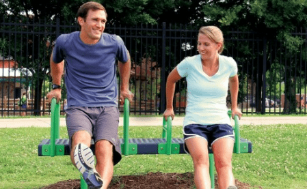 People using outdoor exercise equipment