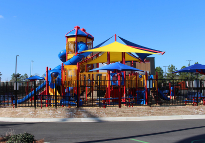 Colorful playground with tall structures and shades.