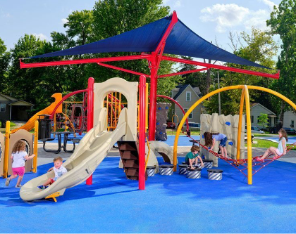 Playground with blue surfacing and shade structure.