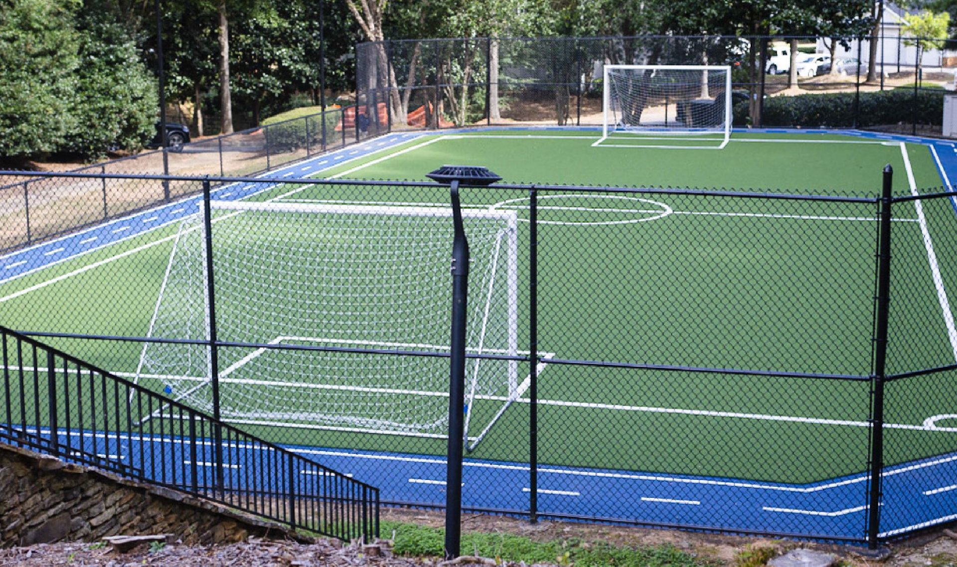 Fenced turf soccer field with track.